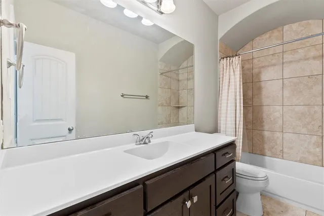 a bathroom with a sink a toilet a mirror and shower