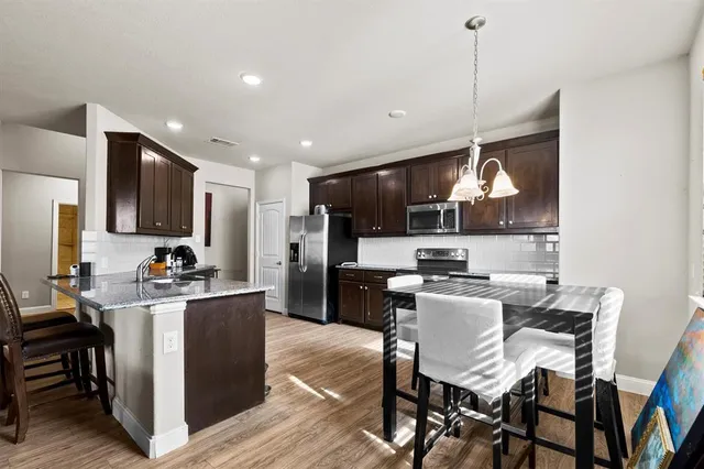 a kitchen with a table chairs refrigerator and microwave