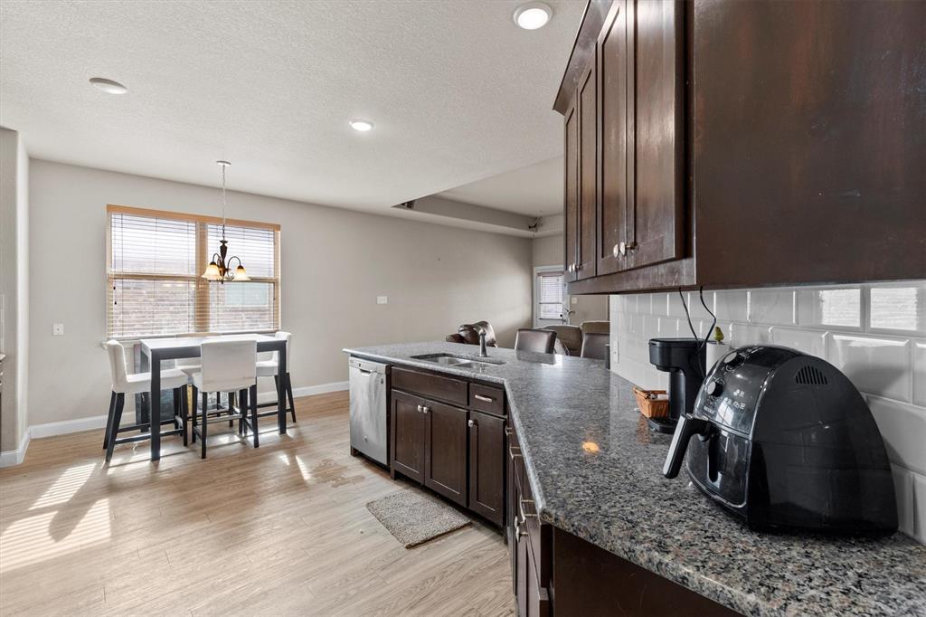 11 Pleasant Valley Sanger, TX 76266 - Photo 7 of 20 a kitchen with granite countertop a stove a sink a dining table and chairs