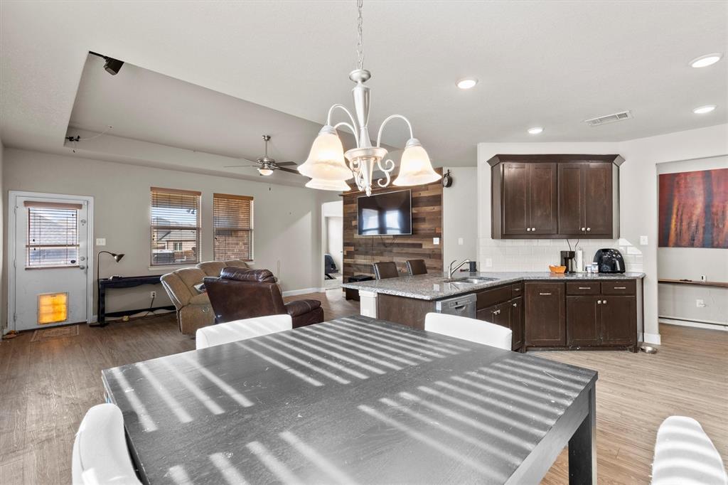 11 Pleasant Valley Sanger, TX 76266 - Photo 9 of 20 a large room with stainless steel appliances kitchen island granite countertop a refrigerator a sink dishwasher a dining table and chairs with wooden floor