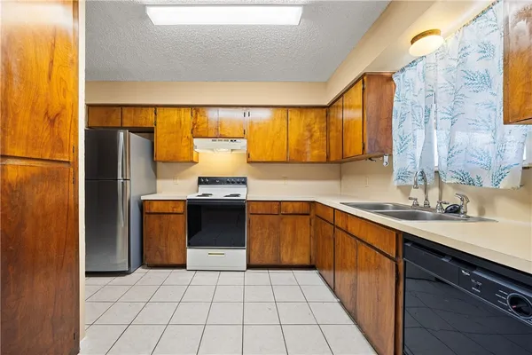 a kitchen with a sink a refrigerator and cabinets