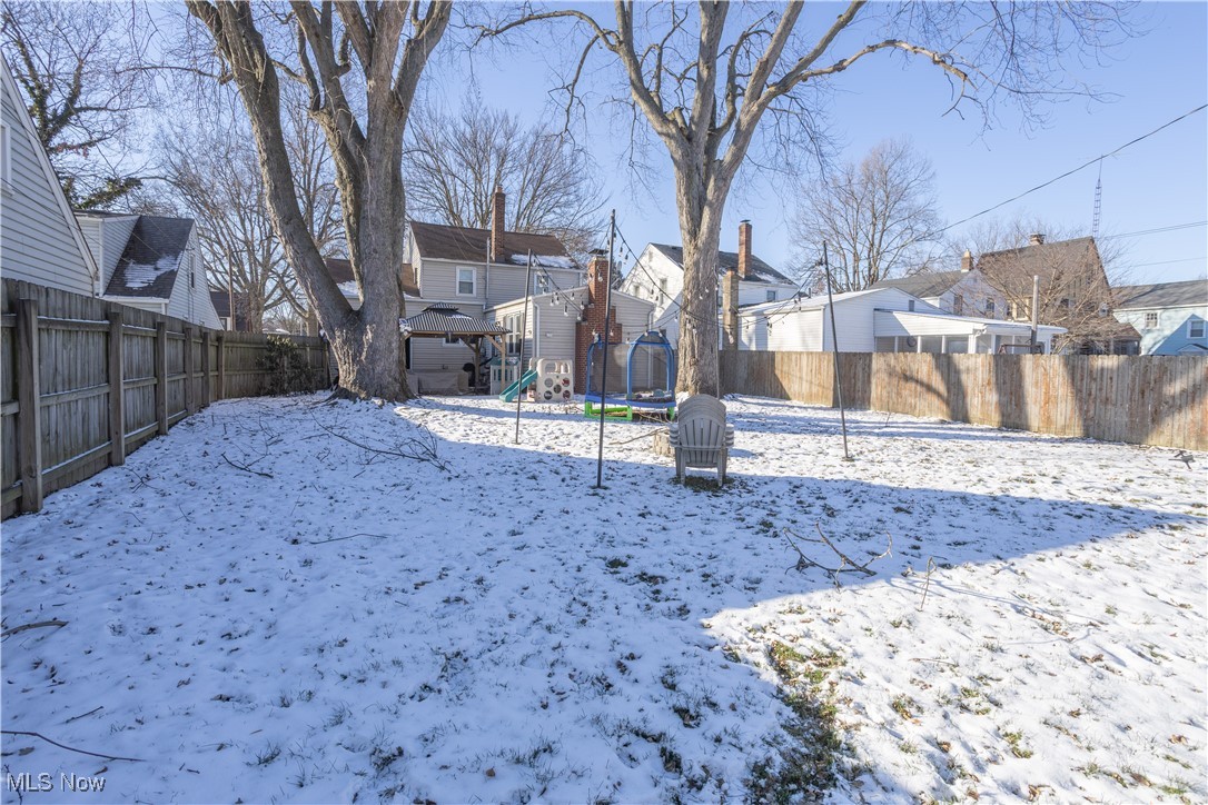 134 Raff Road Northwest Canton, OH 44708 - Photo 26 of 28 Yard layered in snow featuring a playground, a residential view, and a fenced backyard