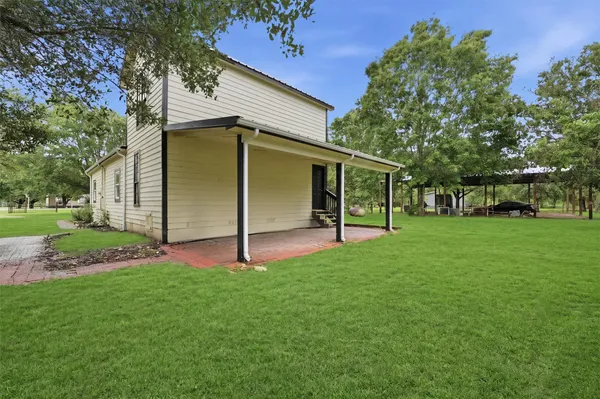 a view of an house with backyard space and a tree