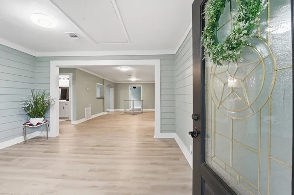 a hallway with wooden floor and potted plant
