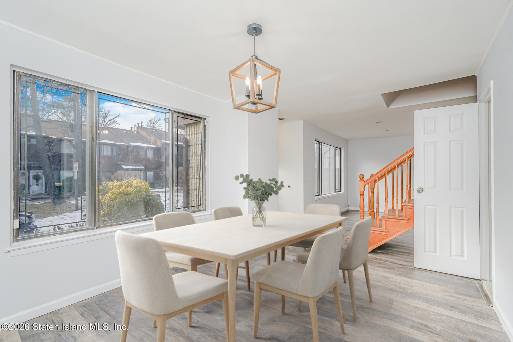 1818 Forest Hill Road Staten Island, NY 10306 - Photo 5 of 36 a dining room with wooden floor a chandelier a wooden table and chairs