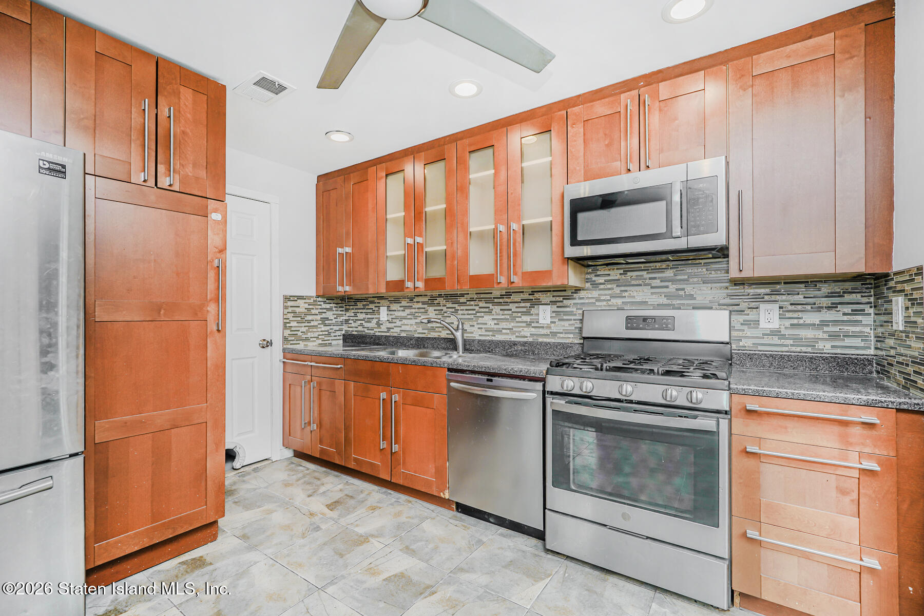 1818 Forest Hill Road Staten Island, NY 10306 - Photo 6 of 36 a kitchen with stainless steel appliances granite countertop a stove microwave and refrigerator