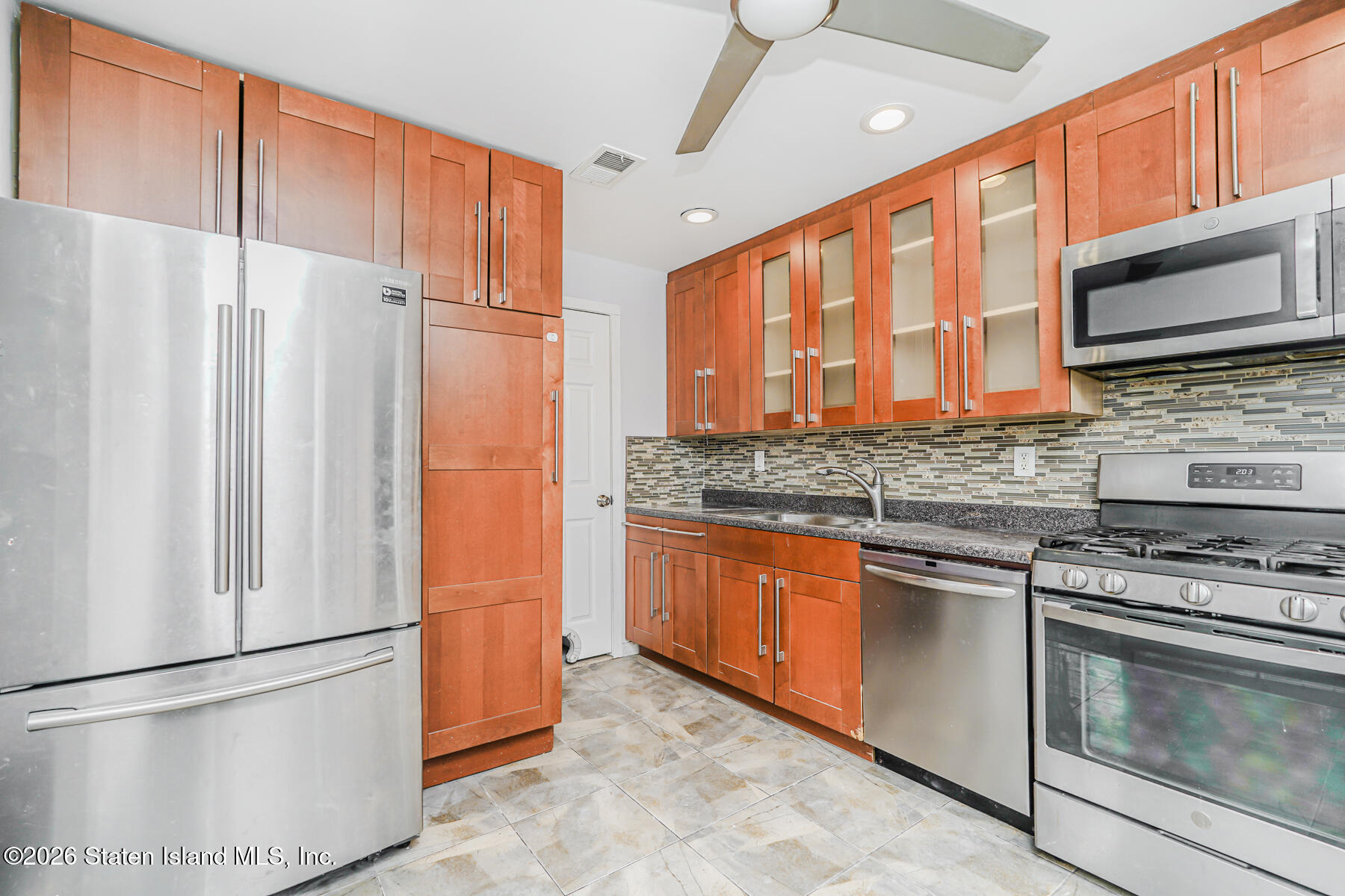 1818 Forest Hill Road Staten Island, NY 10306 - Photo 6 of 36 a kitchen with stainless steel appliances granite countertop a refrigerator a stove a sink and a microwave