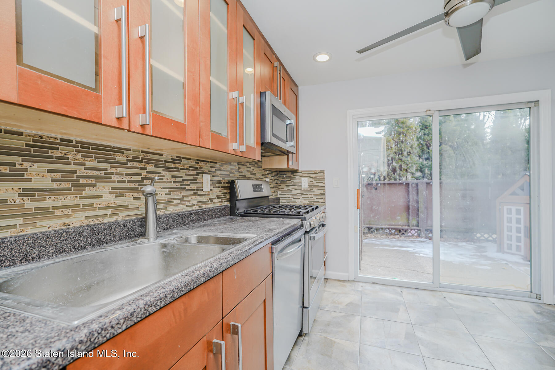 1818 Forest Hill Road Staten Island, NY 10306 - Photo 8 of 36 a kitchen with stainless steel appliances granite countertop a sink and a wooden cabinets