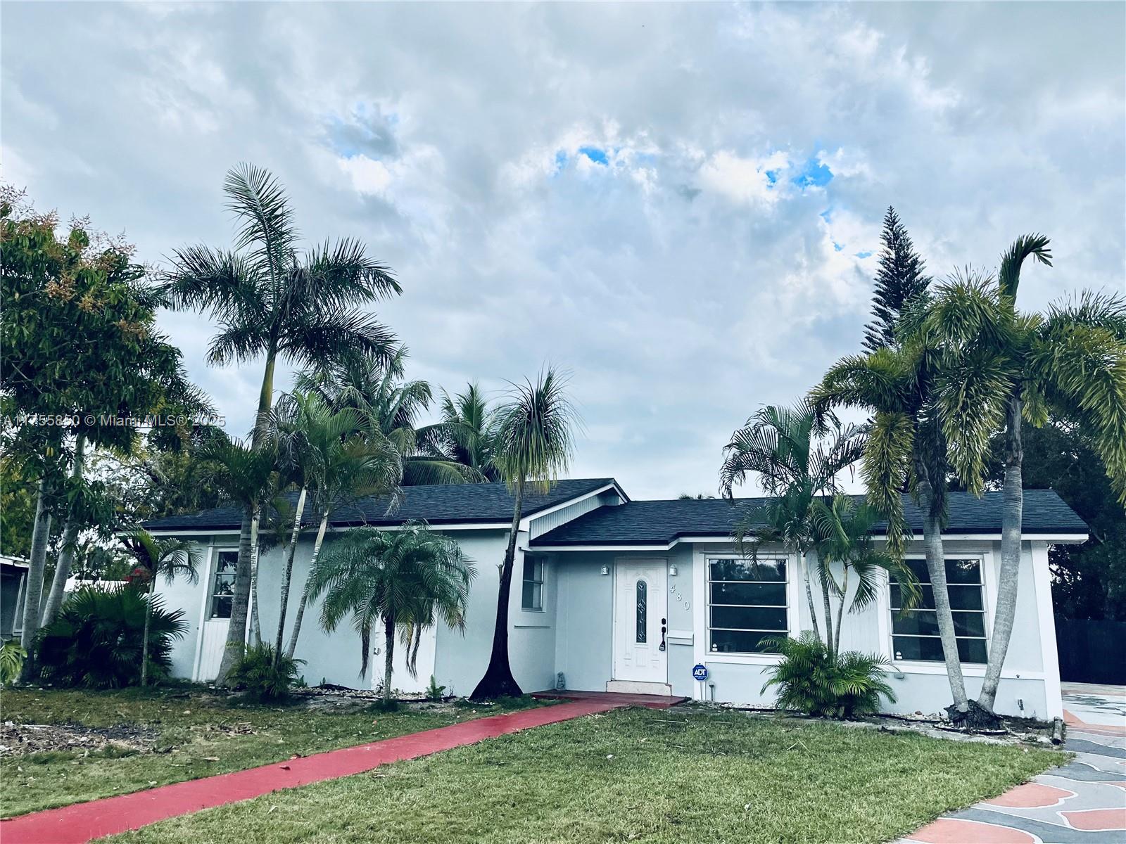 480 Northwest 16th Street Homestead, FL 33030 - Photo 1 of 14 a front view of a house with a yard and potted plants