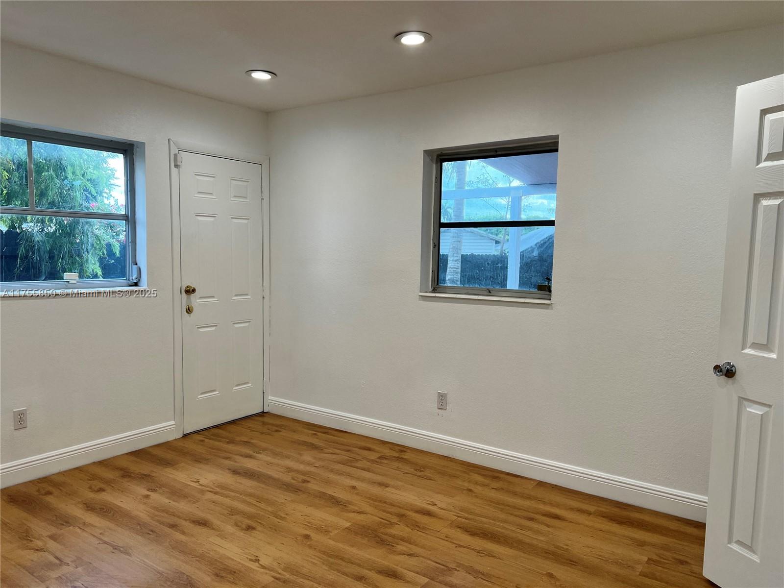 480 Northwest 16th Street Homestead, FL 33030 - Photo 11 of 14 a view of an empty room with wooden floor and a window