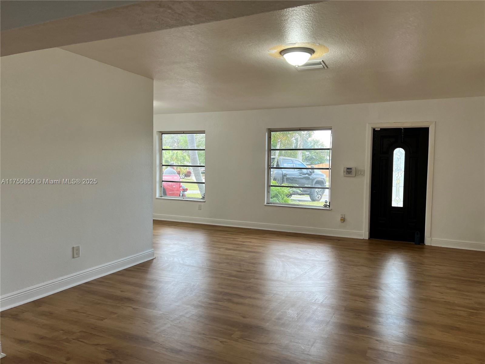 480 Northwest 16th Street Homestead, FL 33030 - Photo 3 of 14 an empty room with wooden floor and windows
