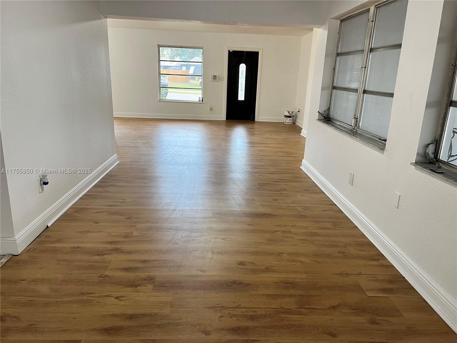 480 Northwest 16th Street Homestead, FL 33030 - Photo 4 of 14 a view of an empty room with wooden floor and a window