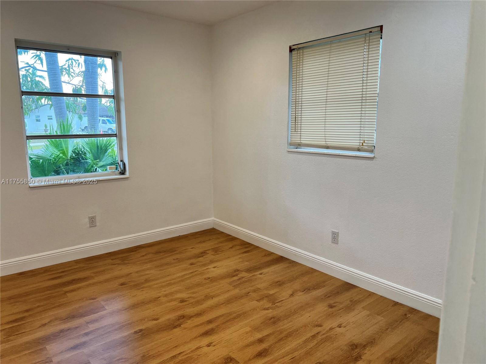 480 Northwest 16th Street Homestead, FL 33030 - Photo 10 of 14 an empty room with wooden floor and windows