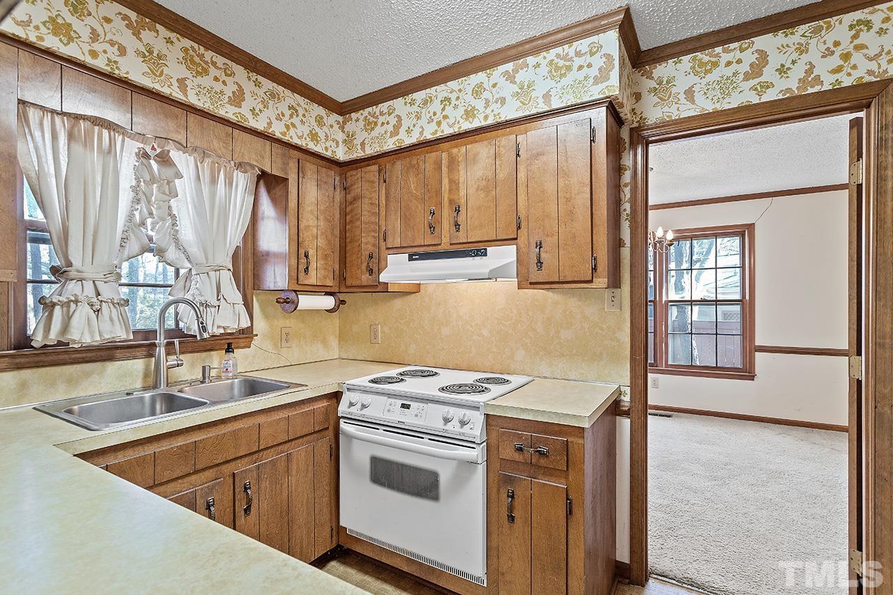 241 Fairview Road Cary, NC 27511 - Photo 11 of 34 a kitchen with a stove a sink and a refrigerator