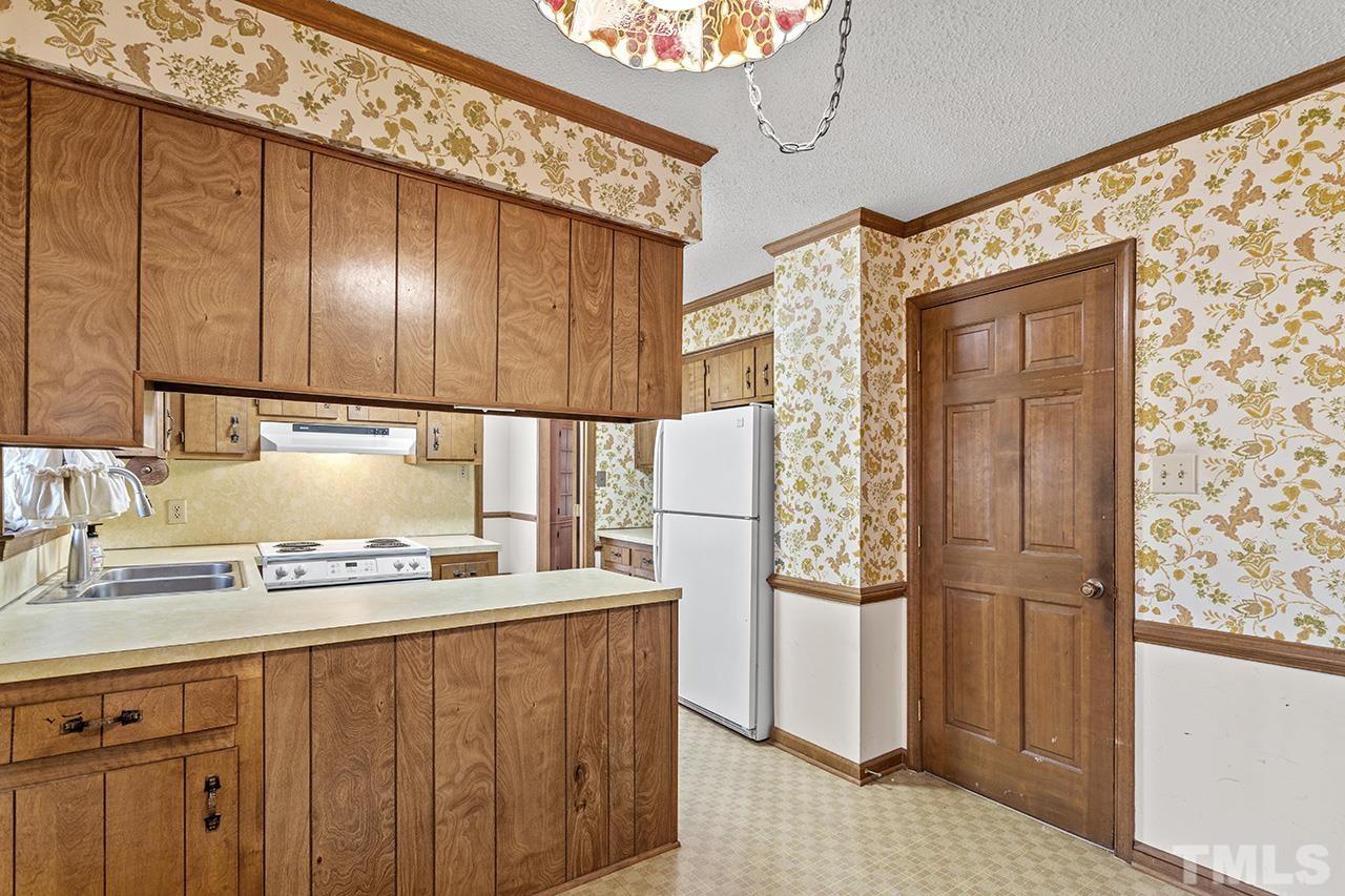 241 Fairview Road Cary, NC 27511 - Photo 14 of 34 a kitchen with a refrigerator and cabinets