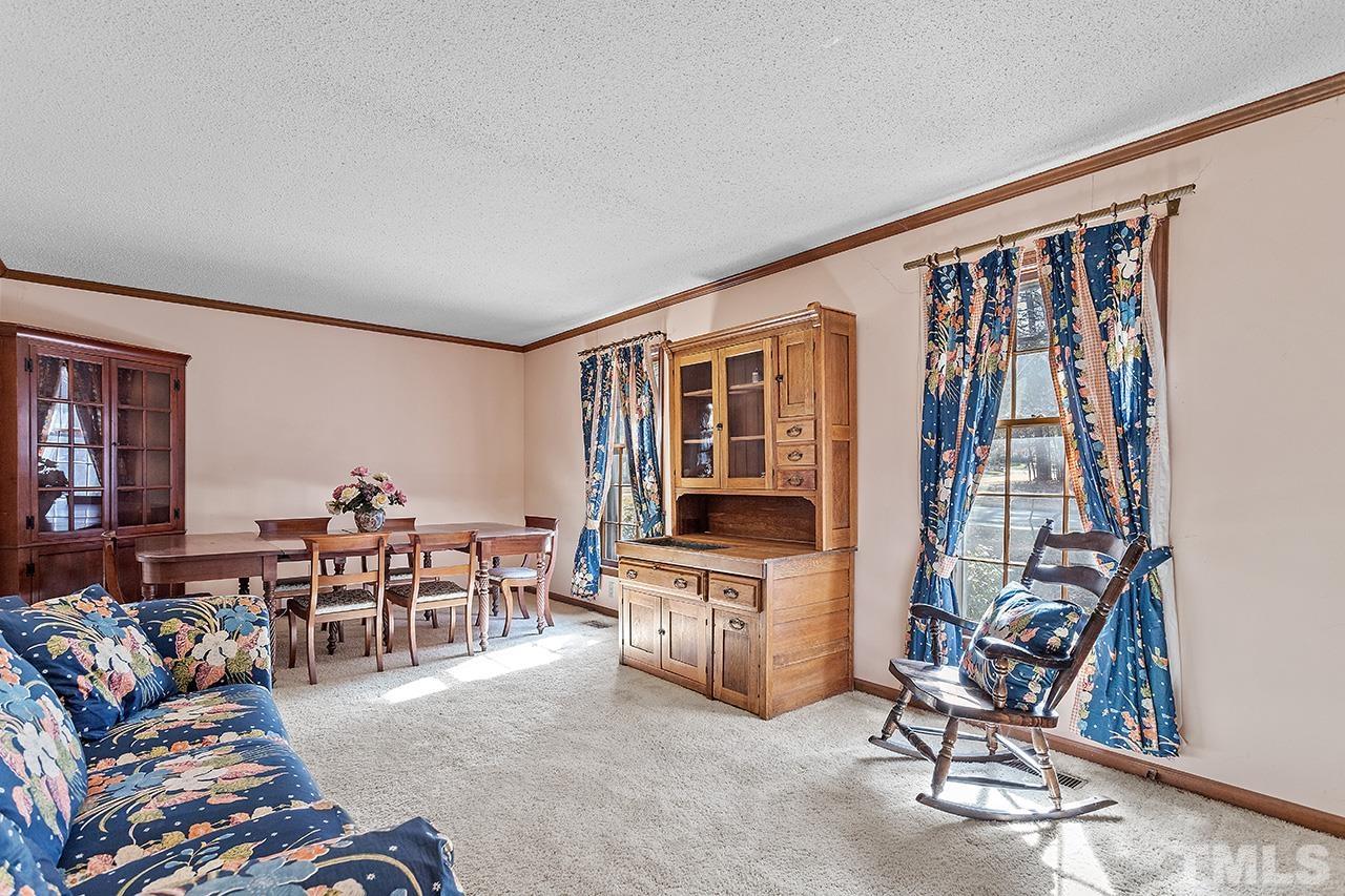 241 Fairview Road Cary, NC 27511 - Photo 7 of 34 a living room with furniture a flat screen tv and a table