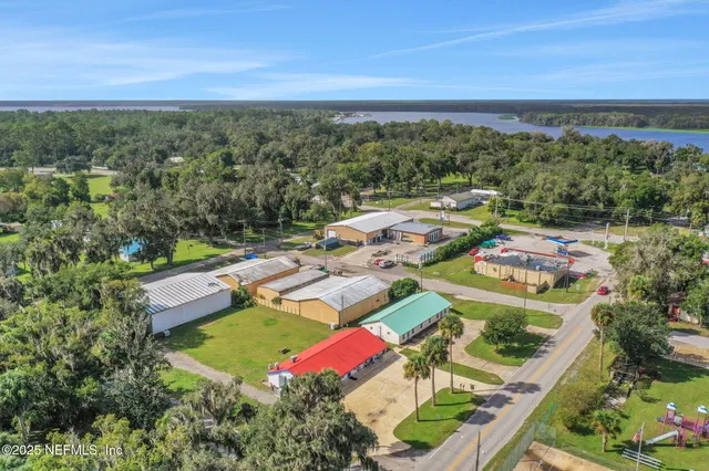 an aerial view of residential houses with outdoor space and trees