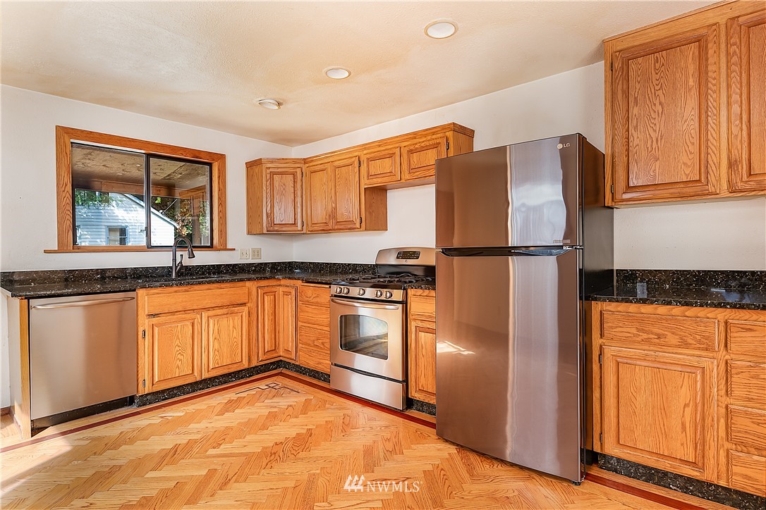 26430 Lake Fenwick Road South Kent, WA 98032 - Photo 7 of 30 a kitchen with stainless steel appliances granite countertop a refrigerator and a stove top oven