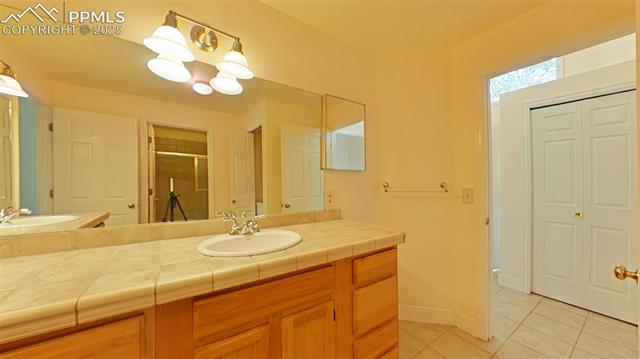 460 Autumn Ridge Circle, Unit D Colorado Springs, CO 80906 - Photo 8 of 38 Bathroom with tile patterned floors, a stall shower, a closet, and vanity