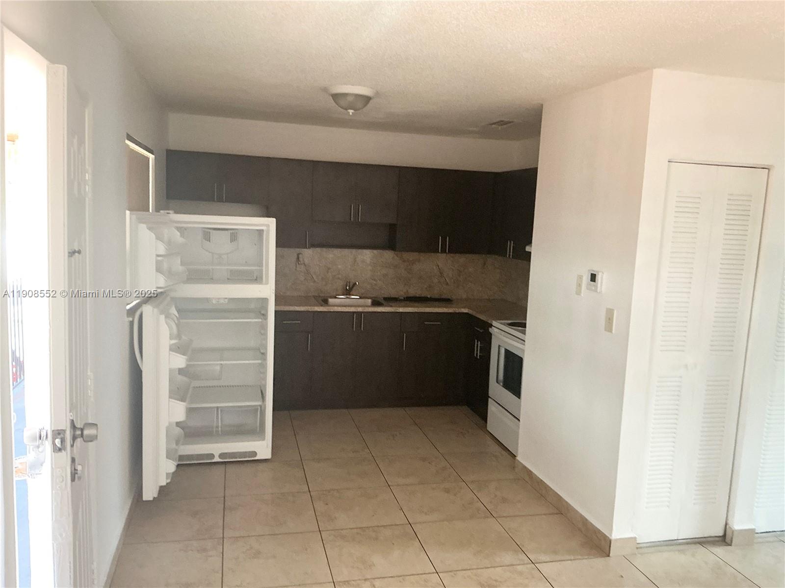 a kitchen with a cabinets and a refrigerator