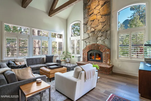 a living room with furniture fireplace and a large window