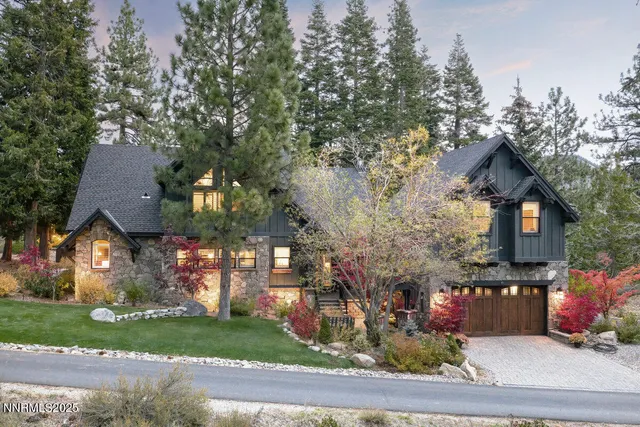 a front view of a house with a yard and tree s