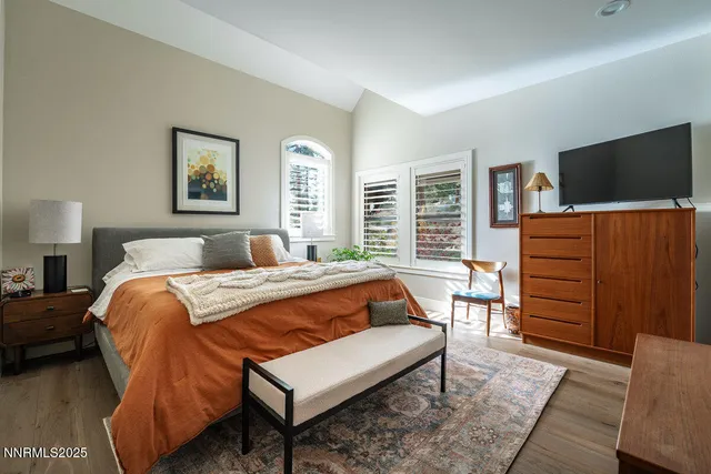 a bedroom with furniture and a flat screen tv