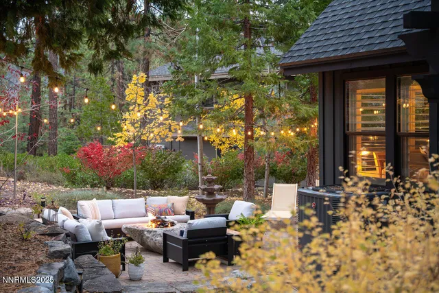 a patio with table and chairs and potted plants