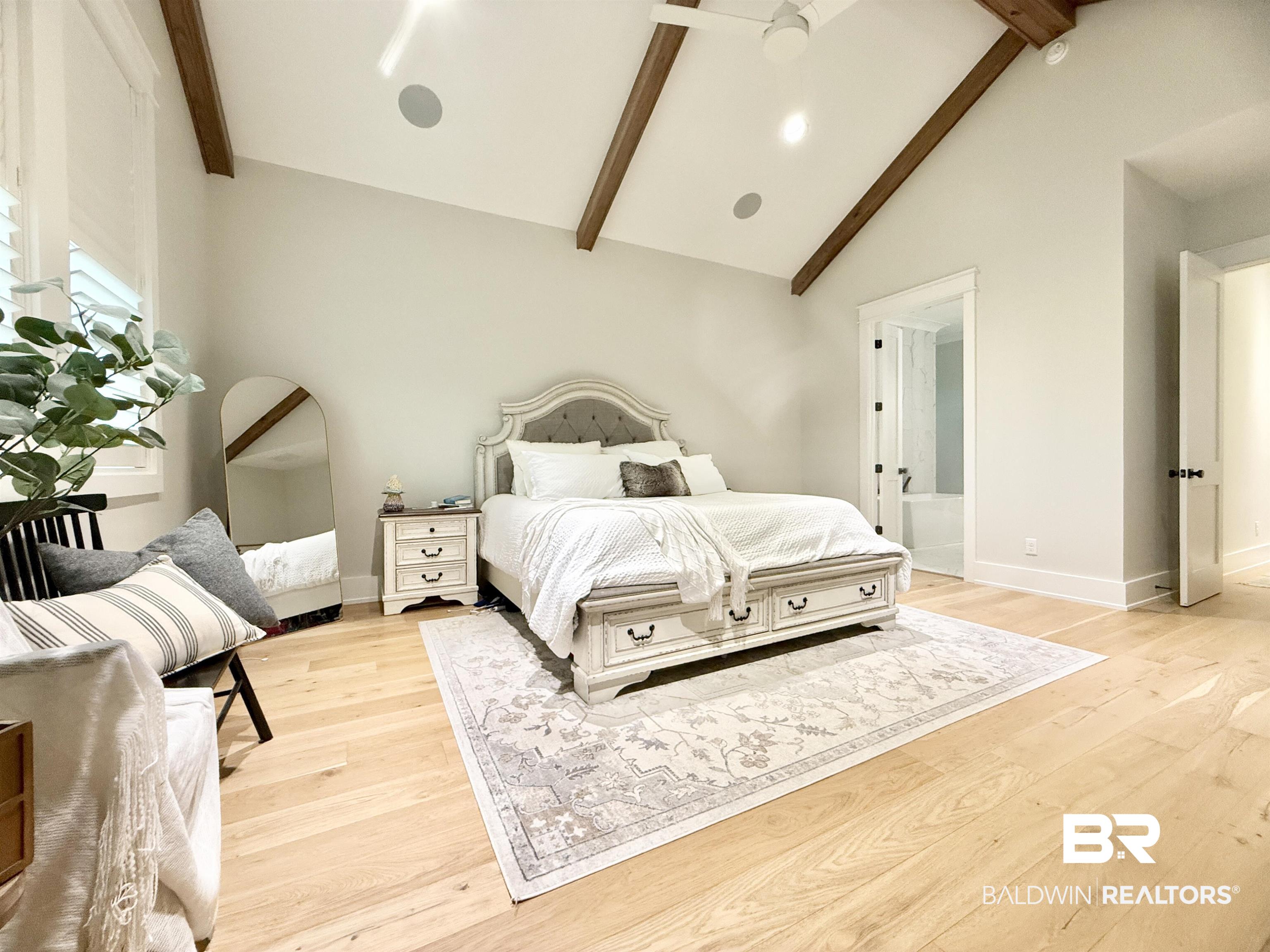 21767 Gallery Boulevard Fairhope, AL 36532 - Photo 26 of 74 Bedroom with beamed ceiling, light wood-style floors, high vaulted ceiling, and connected bathroom