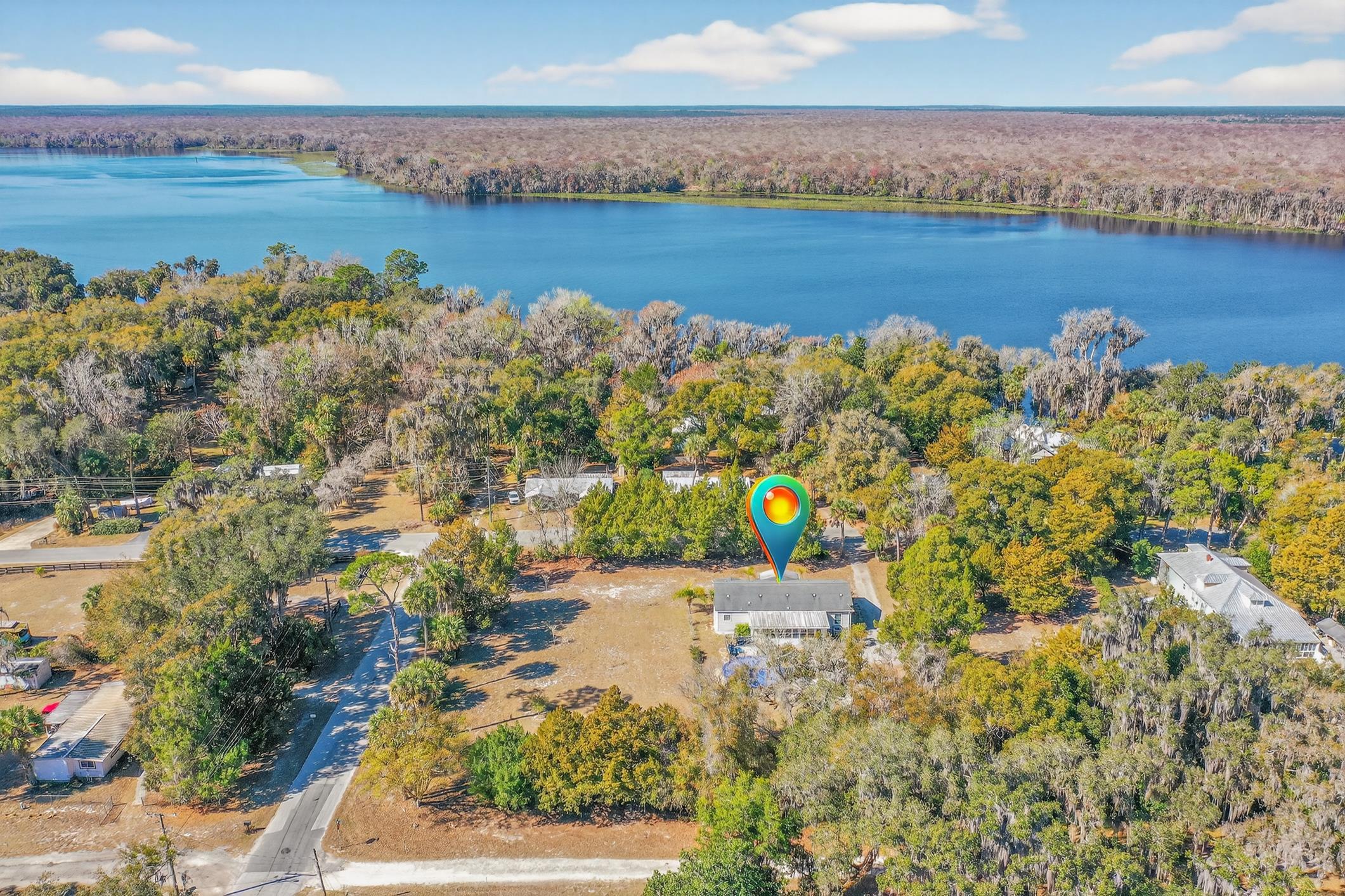 Drone / aerial view of a heavily wooded area and a large body of water