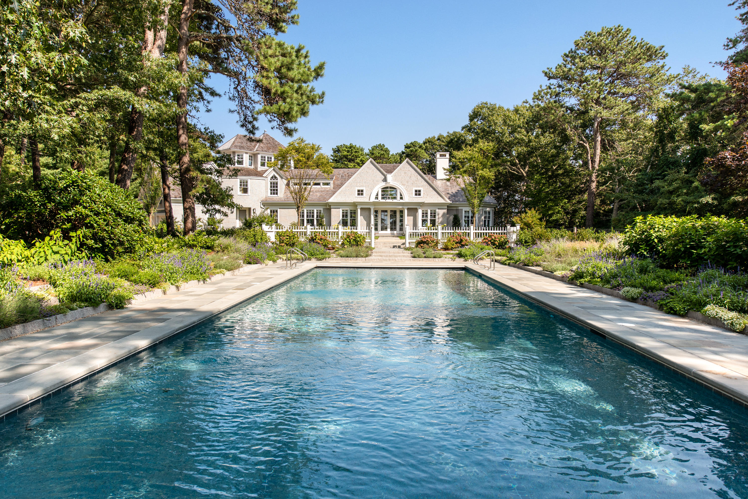 1025 Old Post Road Cotuit, MA 02635 - Photo 2 of 20 a view of swimming pool with outdoor seating and trees in the background