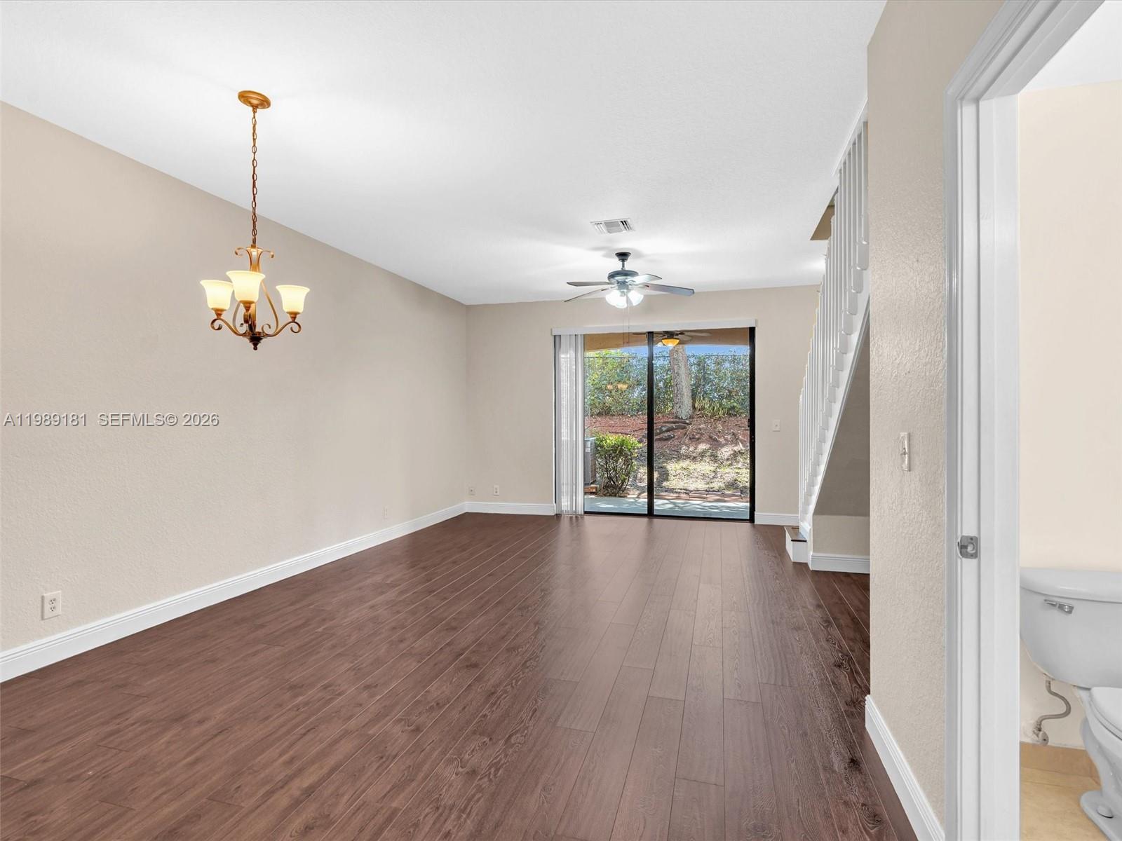 4126 Forest Drive Weston, FL 33332 - Photo 11 of 37 a view of a room with wooden floor chandelier and windows