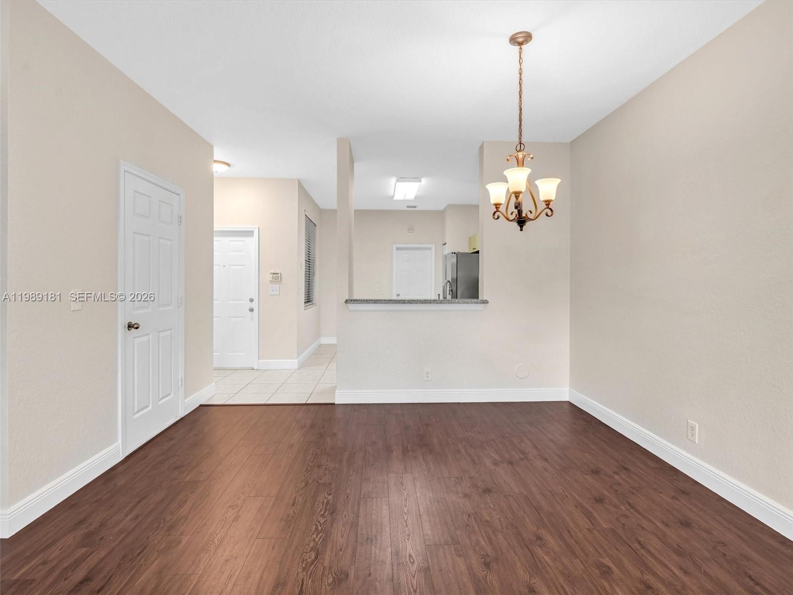 4126 Forest Drive Weston, FL 33332 - Photo 15 of 37 a view of a room with wooden floor and chandelier