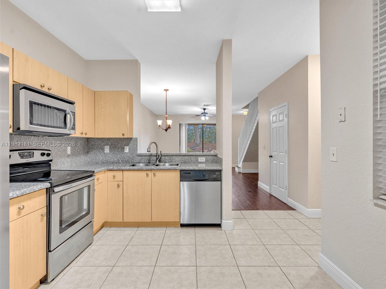 4126 Forest Drive Weston, FL 33332 - Photo 3 of 37 a kitchen with a sink a stove top oven and white cabinets