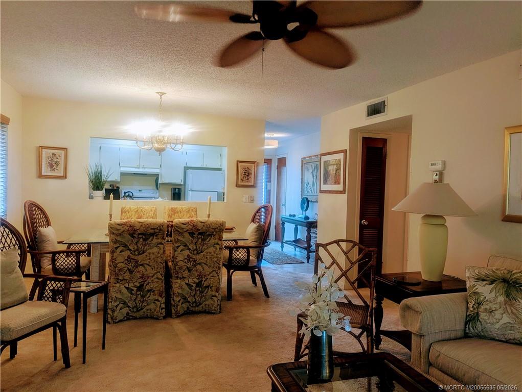 2950 Southeast Ocean Boulevard, Unit 56 Stuart, FL 34996 - Photo 3 of 12 a living room with furniture kitchen view and a chandelier
