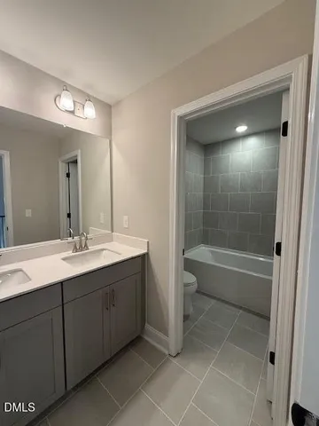 a bathroom with a bathtub shower sink vanity and mirror