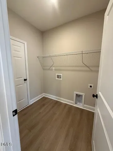 an empty room with wooden floor and white walls