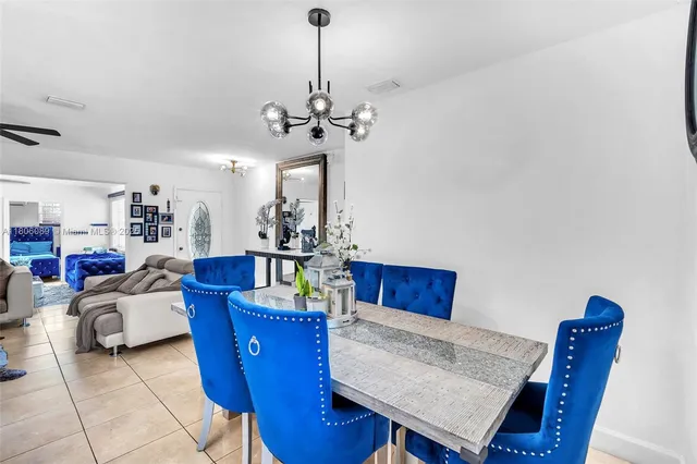 a kitchen with stainless steel appliances kitchen island granite countertop a refrigerator a stove a sink dishwasher and white cabinets with wooden floor