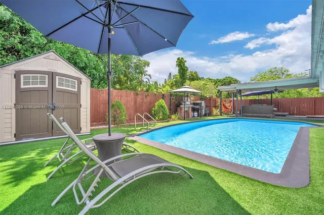 a view of a backyard with swimming pool and furniture