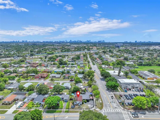 an aerial view of residential houses with outdoor space and trees