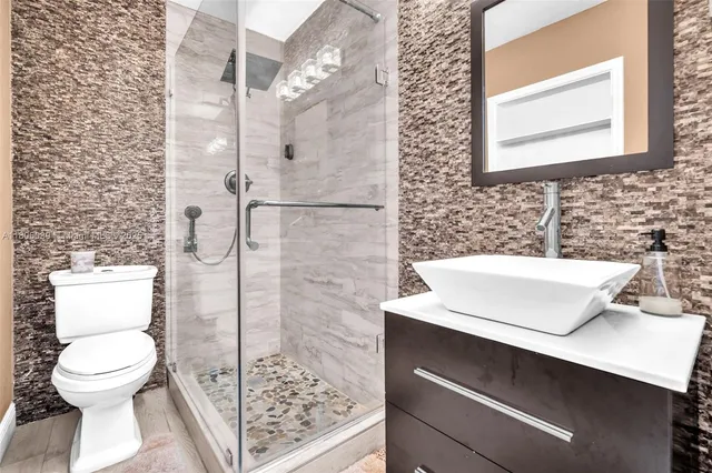 a bathroom with a sink toilet and shower