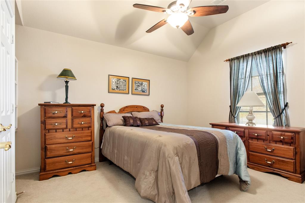 1614 Villa Court Corinth, TX 76210 - Photo 12 of 17 Bedroom featuring light colored carpet, lofted ceiling, and a ceiling fan
