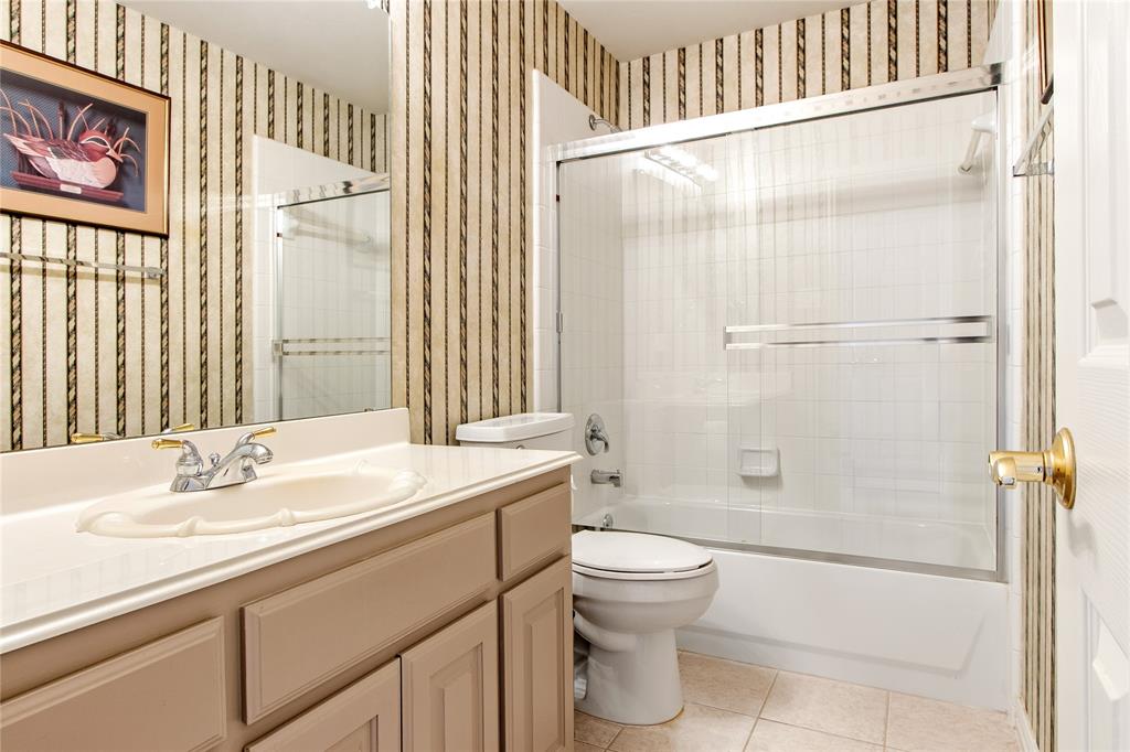 1614 Villa Court Corinth, TX 76210 - Photo 15 of 17 Full bath featuring wallpapered walls, bath / shower combo with glass door, vanity, and light tile patterned floors