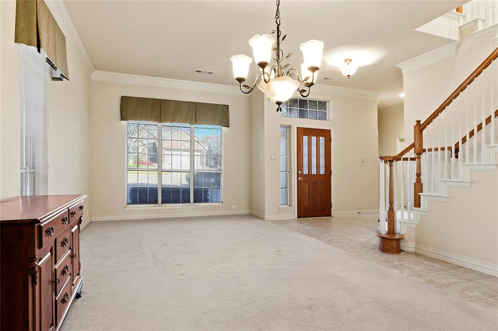1614 Villa Court Corinth, TX 76210 - Photo 3 of 17 view of Living room featuring ornamental molding, light carpet, light tile patterned floors, a chandelier, and stairway