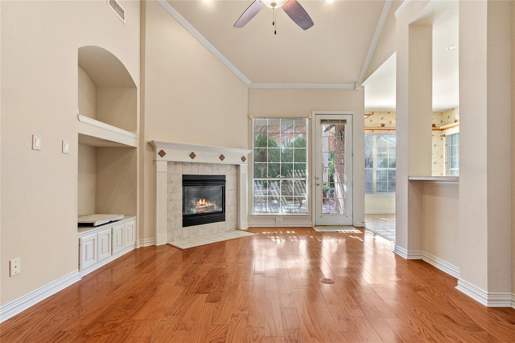 1614 Villa Court Corinth, TX 76210 - Photo 4 of 17 Unfurnished family room with light wood-style flooring, built in features, ornamental molding, a fireplace, and ceiling fan