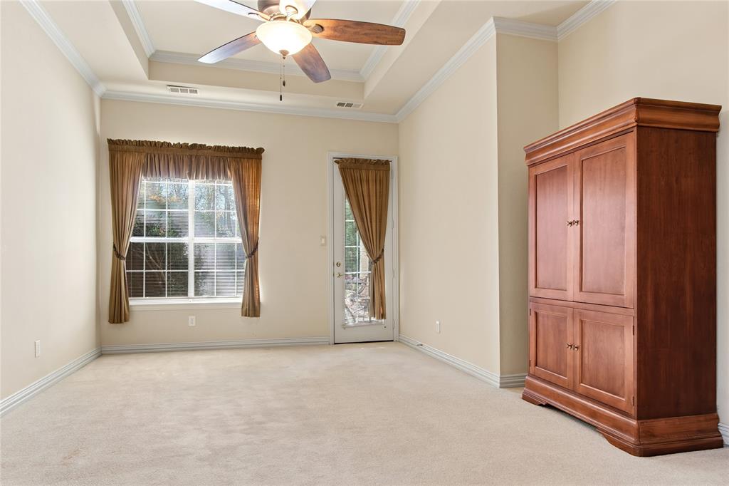 1614 Villa Court Corinth, TX 76210 - Photo 10 of 17 Unfurnished primary bedroom with light colored carpet, a tray ceiling, access to outside, ceiling fan, and ornamental molding