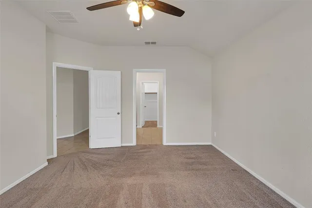 an empty room with chandelier fan