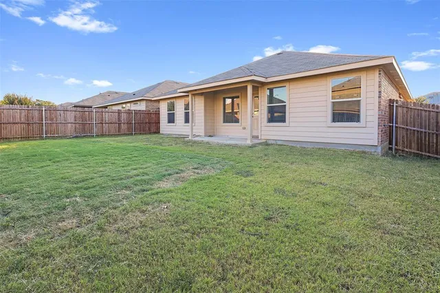 a view of a backyard with plants and wooden fence