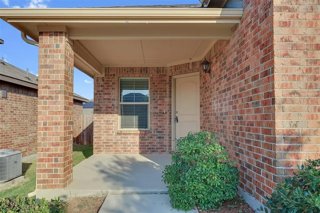 a view of a brick house with potted plants