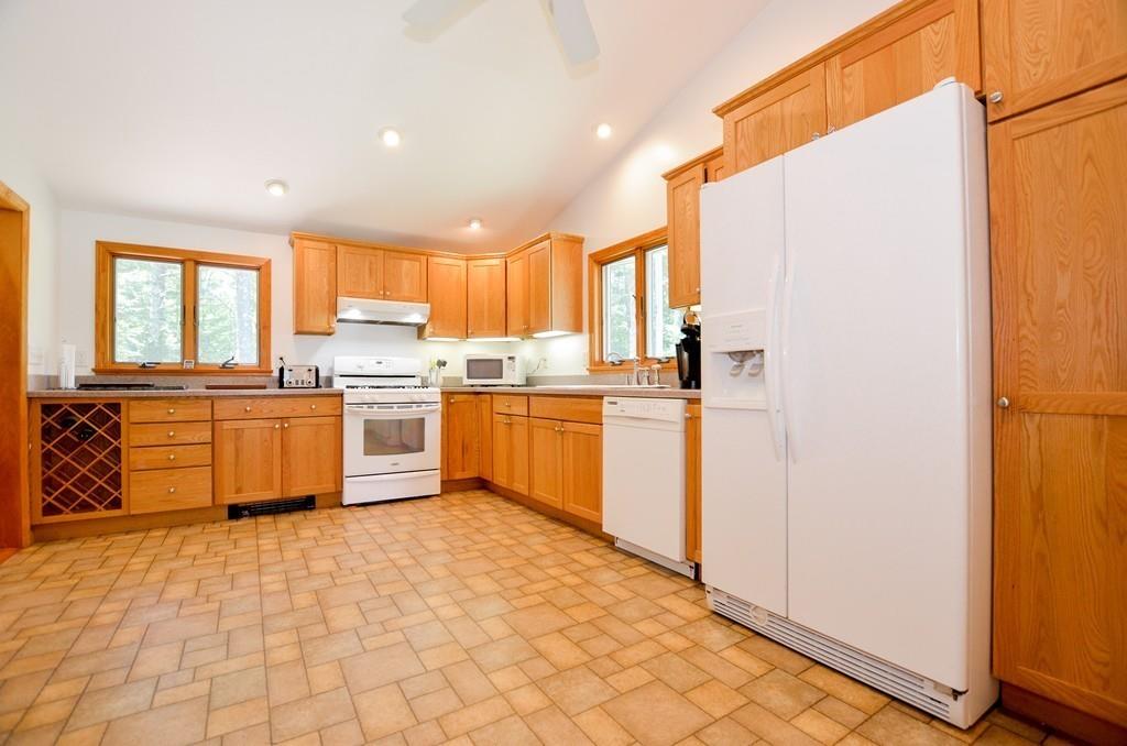 899 Walnut Plain Road Rochester, MA 02770 - Photo 15 of 42 a kitchen with stainless steel appliances granite countertop a stove a sink a refrigerator and cabinets